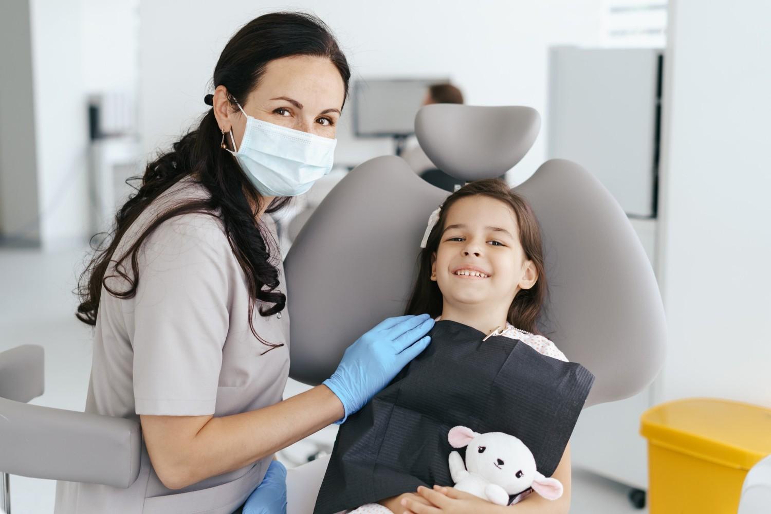 Cute little girl sitting in the dentists office